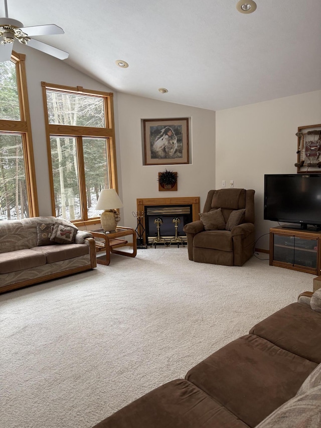 carpeted living room with ceiling fan, a fireplace, and vaulted ceiling