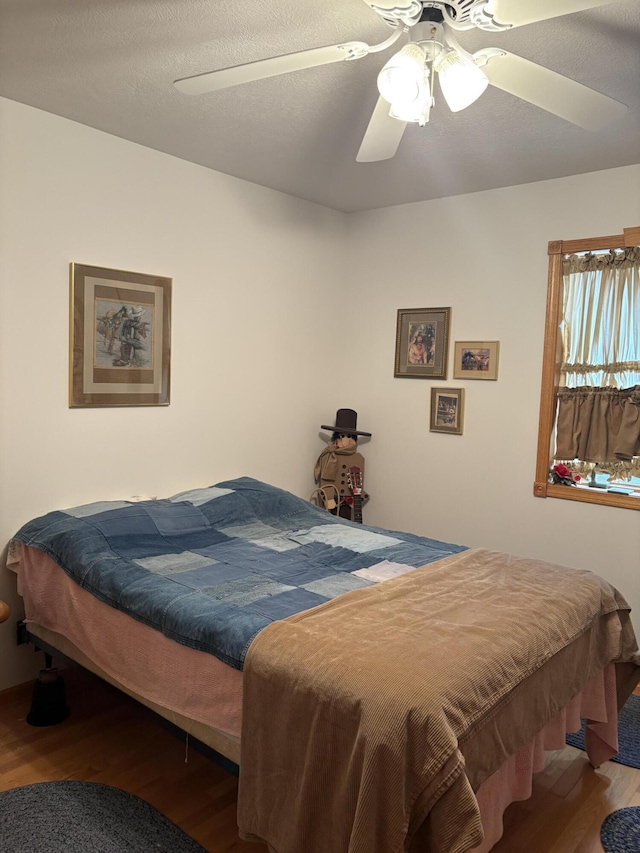 bedroom with ceiling fan and hardwood / wood-style floors