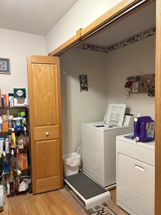 laundry room featuring washer and dryer and light wood-type flooring