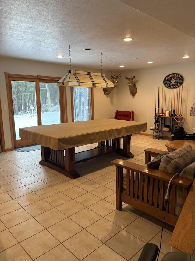 recreation room featuring a textured ceiling and light tile patterned floors