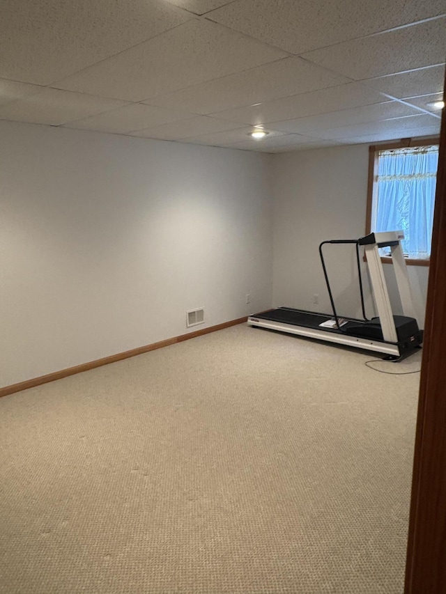 exercise room featuring carpet flooring and a drop ceiling