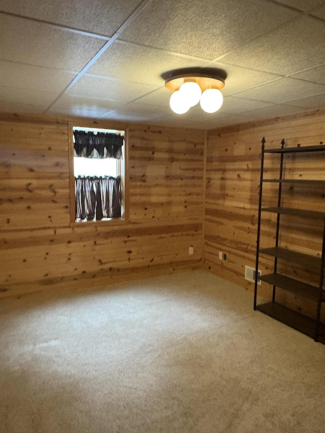 empty room with carpet flooring and wood walls