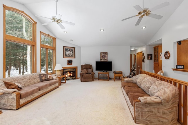 carpeted living room with ceiling fan and high vaulted ceiling