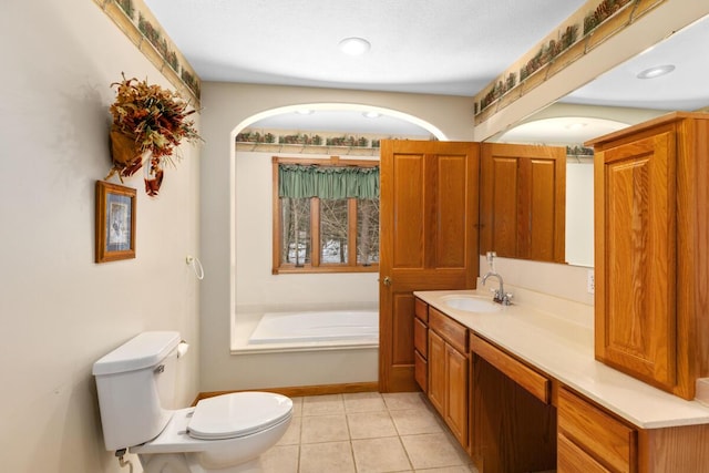 bathroom with tile patterned floors, a tub to relax in, toilet, and vanity