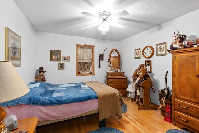 bedroom featuring ceiling fan, a textured ceiling, and light wood-type flooring