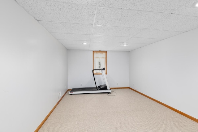 exercise area featuring carpet and a paneled ceiling