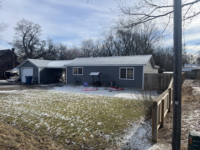 snow covered back of property featuring a garage