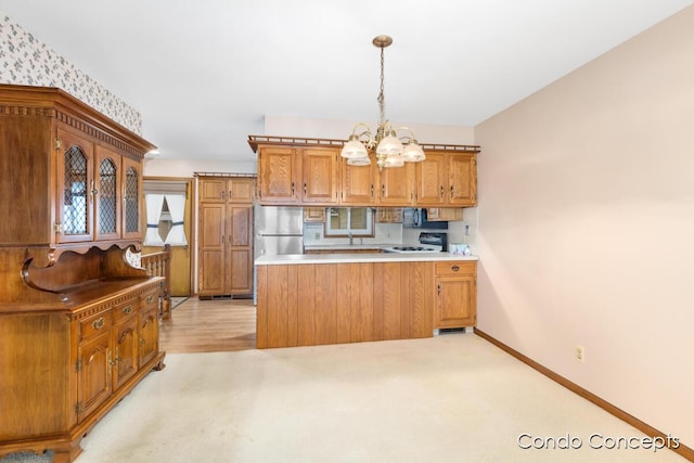 kitchen featuring decorative light fixtures, light carpet, stainless steel refrigerator, a notable chandelier, and stove