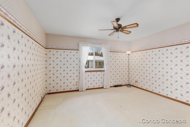 carpeted spare room featuring ceiling fan