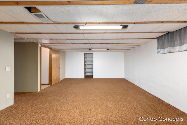 basement with a paneled ceiling and carpet flooring