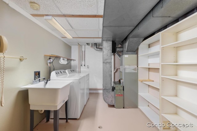 washroom featuring heating unit, sink, and washer and clothes dryer