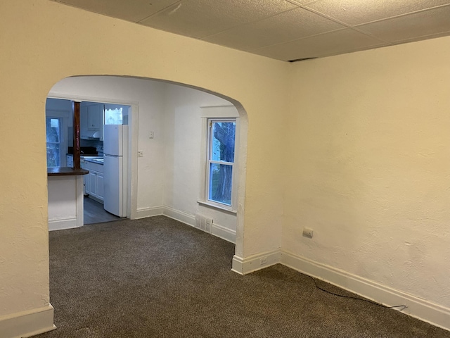 carpeted spare room featuring a paneled ceiling