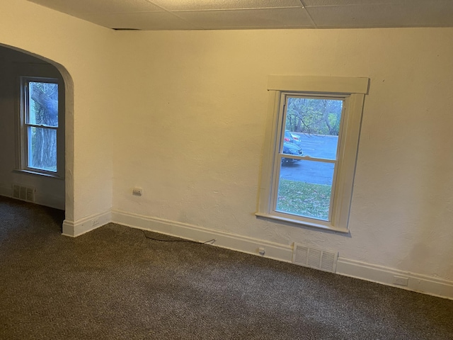 carpeted spare room featuring a drop ceiling