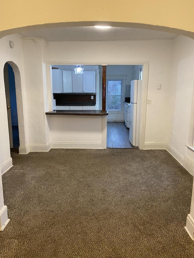 unfurnished living room featuring dark carpet