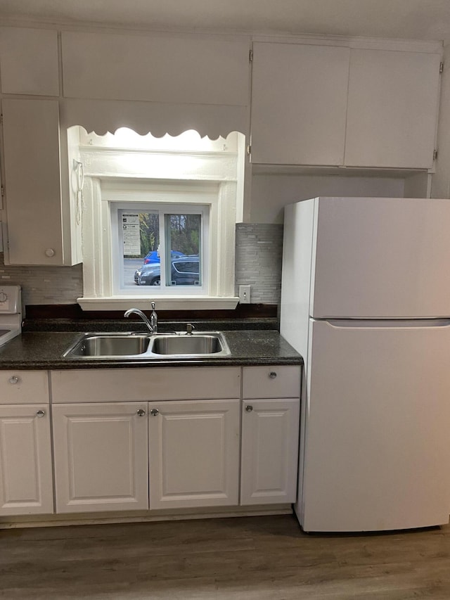 kitchen with tasteful backsplash, sink, white cabinets, and white fridge