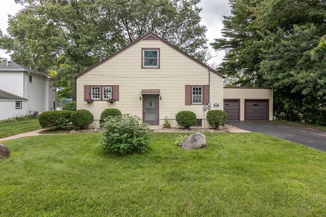 view of front of house featuring a garage, an outbuilding, and a front yard