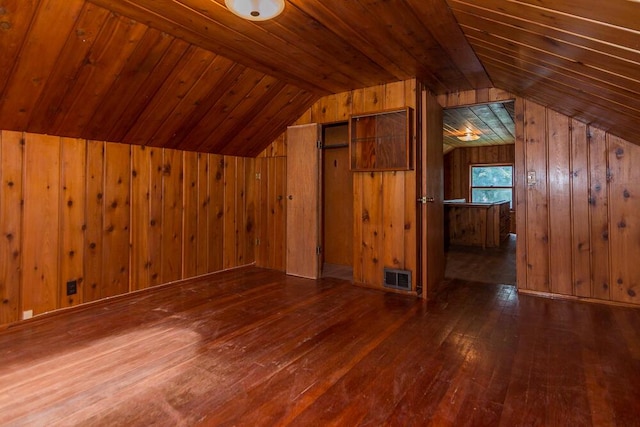 bonus room with lofted ceiling, dark hardwood / wood-style floors, wooden ceiling, and wood walls