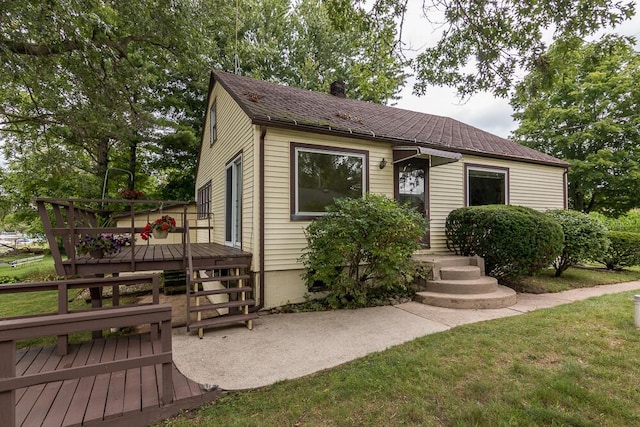 view of front of home featuring a wooden deck and a front lawn