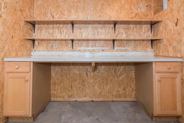 bar featuring concrete flooring and light brown cabinets