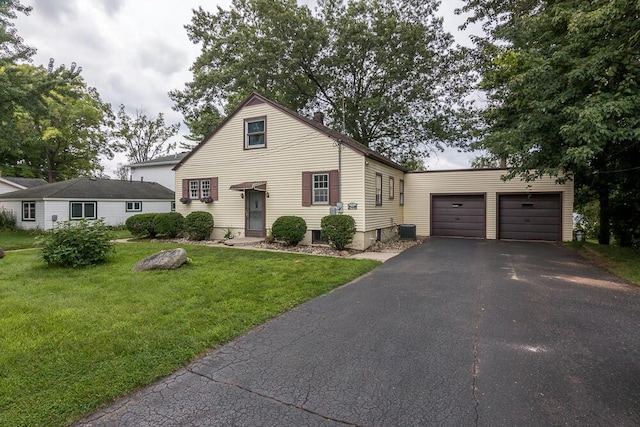 view of front of home featuring a garage, a front yard, and central air condition unit