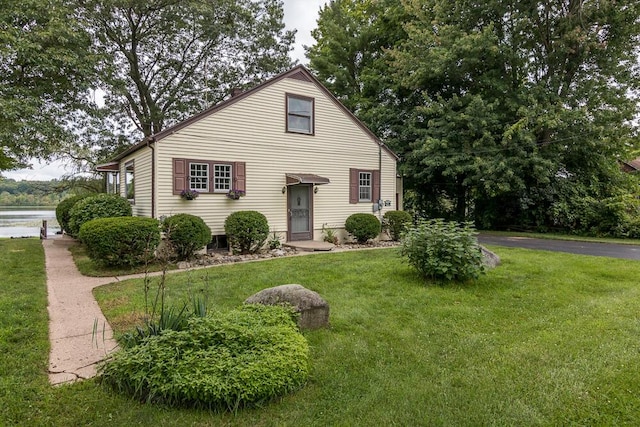 view of front of house with a front yard and a water view