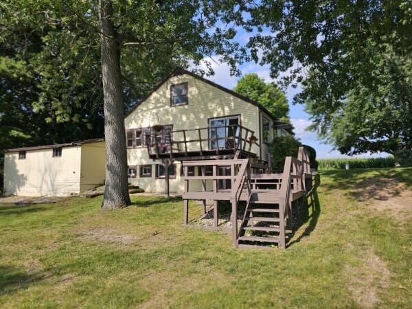 back of house featuring a wooden deck and a yard