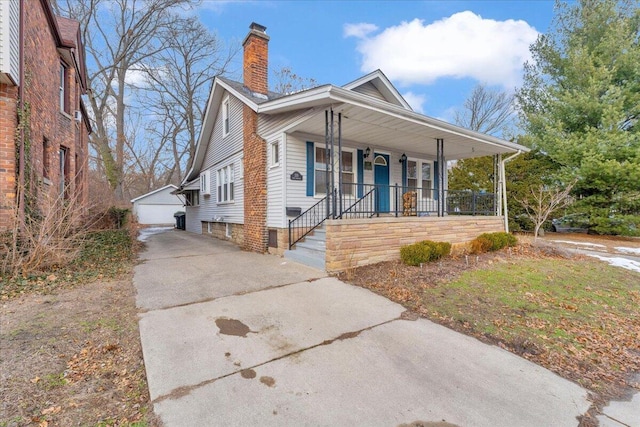 view of front of house with a garage, an outdoor structure, and covered porch