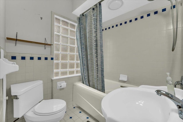 full bathroom featuring tile patterned floors, toilet, sink, and tile walls