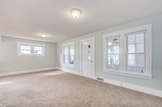 entrance foyer featuring a textured ceiling and carpet flooring