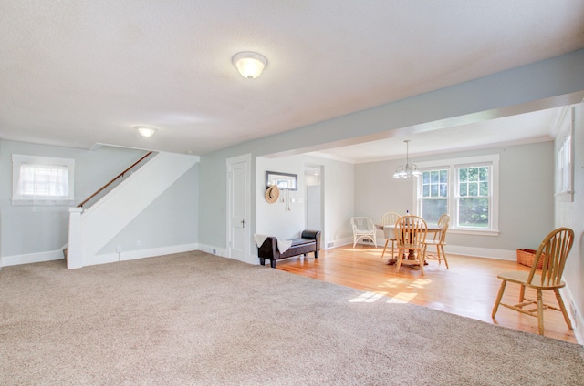 interior space with ornamental molding, light colored carpet, a chandelier, and a healthy amount of sunlight