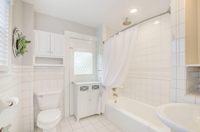 full bathroom featuring sink, tile walls, tile patterned flooring, toilet, and shower / bathtub combination with curtain