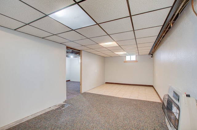 basement featuring heating unit, light colored carpet, and a drop ceiling