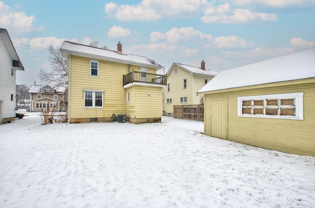 snow covered property with a balcony and central AC