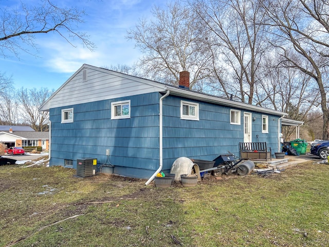 rear view of property with a yard and cooling unit