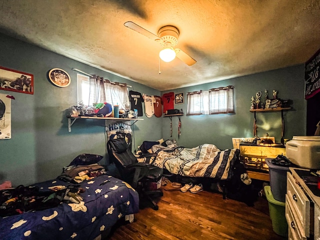 bedroom featuring hardwood / wood-style flooring, ceiling fan, and a textured ceiling