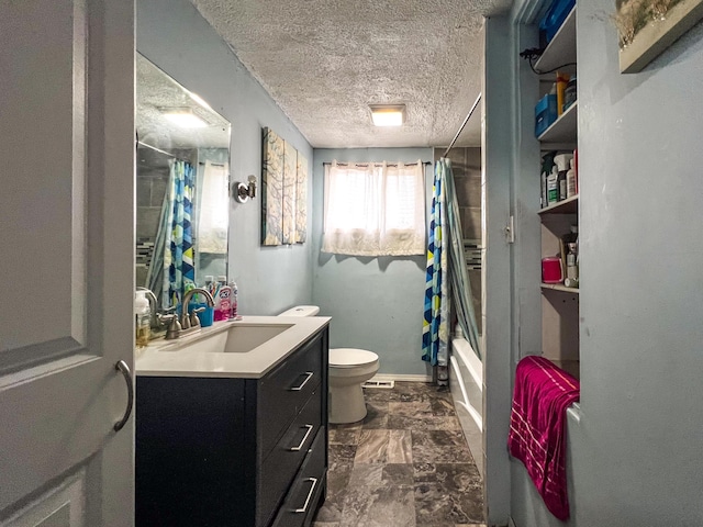 full bathroom featuring shower / tub combo with curtain, vanity, toilet, and a textured ceiling