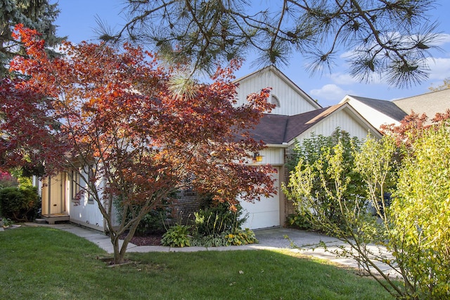 view of property hidden behind natural elements featuring a garage and a front yard