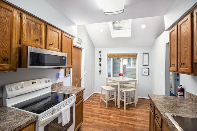 kitchen featuring lofted ceiling with skylight, dark wood-type flooring, and white electric range