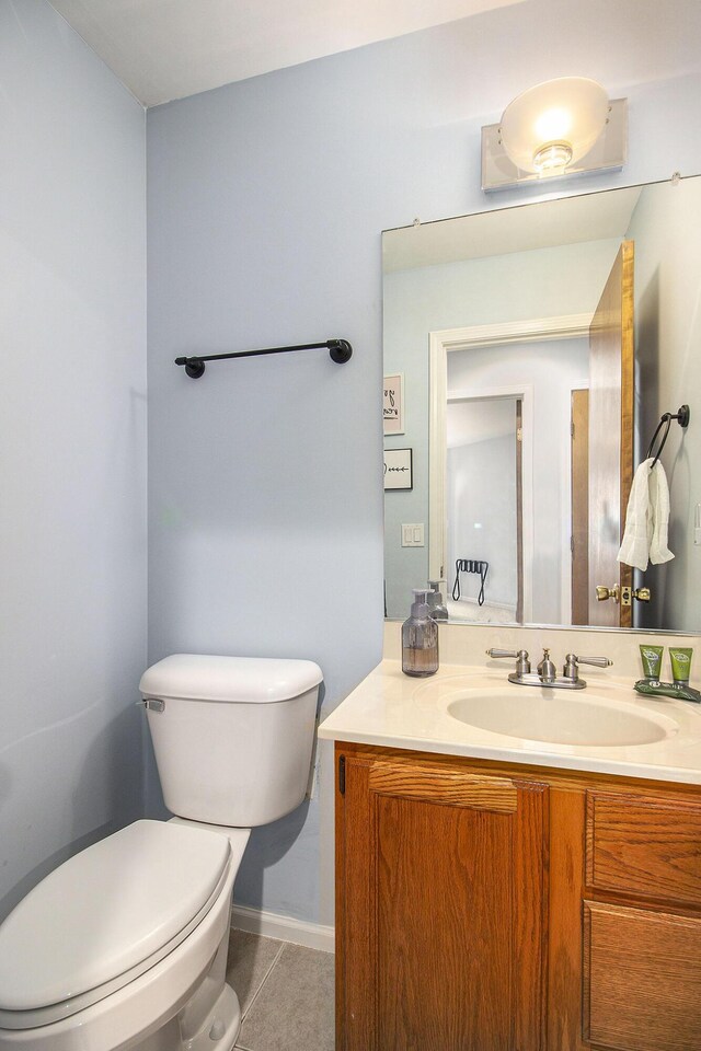 bathroom featuring tile patterned floors, vanity, and toilet