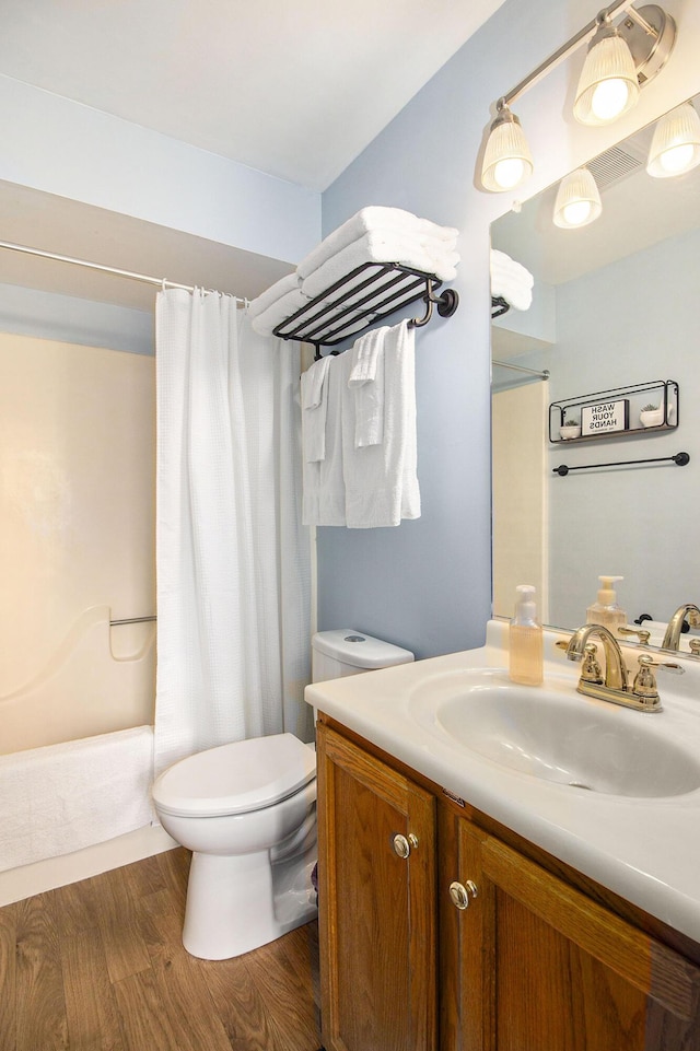 full bathroom with hardwood / wood-style flooring, vanity, toilet, and shower / bath combo