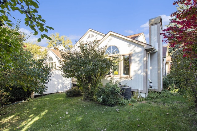 view of home's exterior with central AC and a lawn