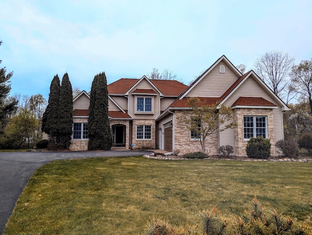 168 Pheasant Run, Battle Creek, MI 49015 - craftsman-style home with aphalt driveway, stone siding, and a front yard