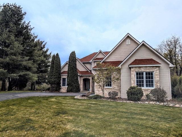 168 Pheasant Run, Battle Creek, MI 49015 - view of front of property featuring brick siding, a front yard, and aphalt driveway