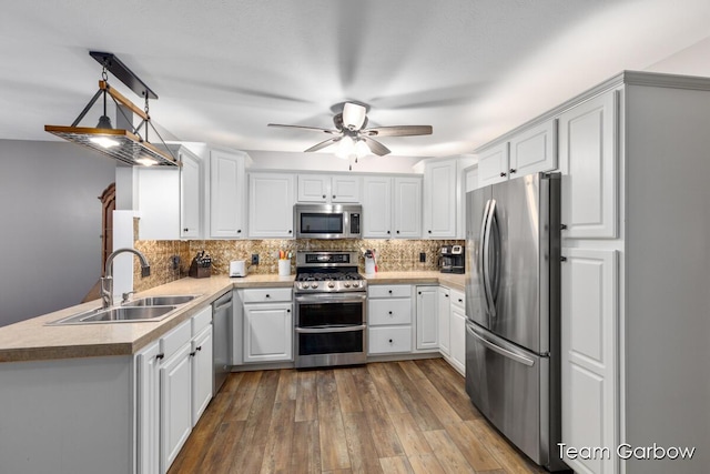 kitchen featuring appliances with stainless steel finishes, sink, white cabinets, and backsplash