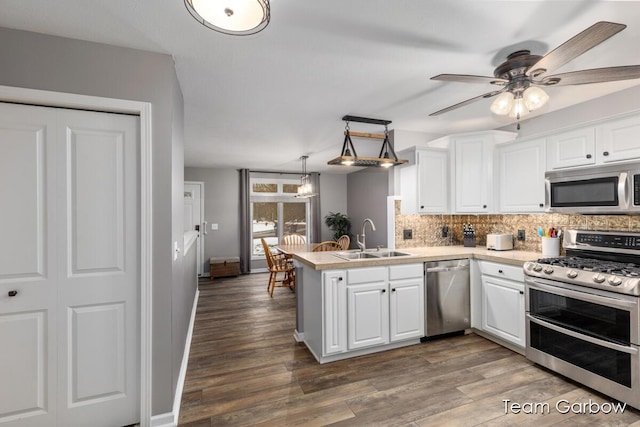 kitchen featuring white cabinetry, stainless steel appliances, kitchen peninsula, and sink