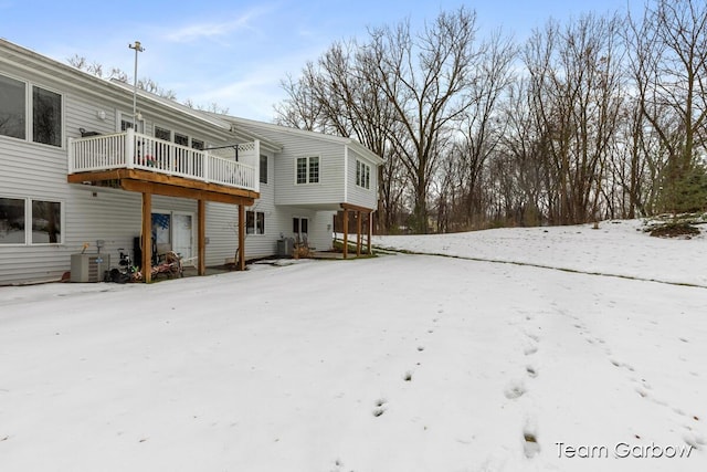 snow covered house with a wooden deck and central AC