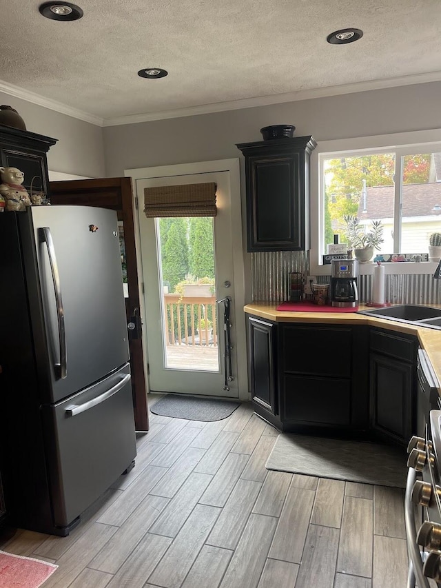 kitchen with ornamental molding, appliances with stainless steel finishes, sink, and a wealth of natural light