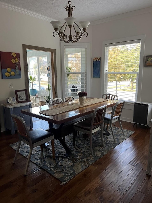 dining room featuring an inviting chandelier, ornamental molding, dark hardwood / wood-style floors, and a textured ceiling