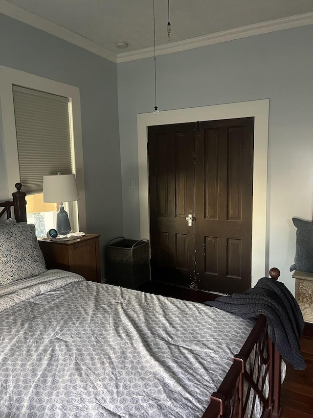 bedroom featuring ornamental molding and hardwood / wood-style floors