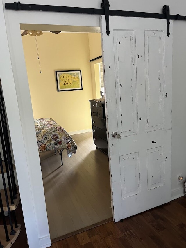 interior space with a barn door and dark hardwood / wood-style flooring